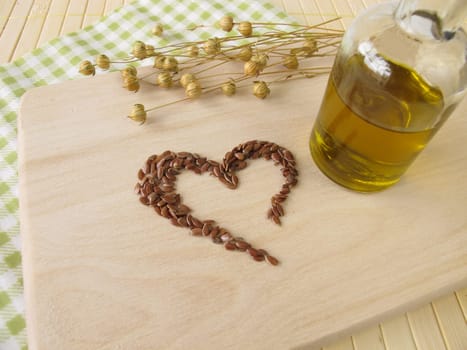 A heart of flaxseed and a bottle of flaxseed oil
