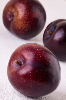 Fresh shiny juicy plums with ripe color with stem up as close-up