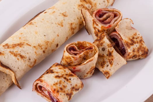 Pancake crepes tortilla filled with maraufas as dessert on a white plate