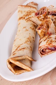 Pancake crepes tortilla filled with maraufas as dessert on a white plate