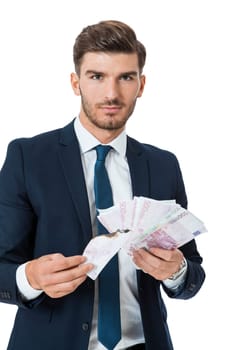 Wealthy successful young businessman with a handful of euro banknotes with a happy smile shows his wealth isolated on white