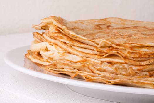 delicious fresh crepes pancakes pancakes on a white plate on a rustic white wooden board