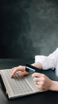 Elegance in E-commerce. Woman's Hands Grasp Credit Card, Navigate Online Shopping with Laptop - Conceptual Image. Chic Shopper. Woman Using Laptop and Credit Card for Online Purchase.