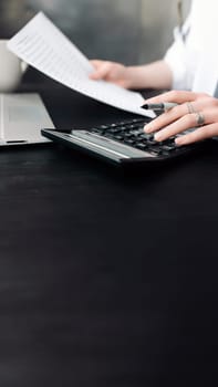 Focused Businesswoman Analyzing Financial Budget: Accounting, Finance Report, Calculator, and Document Close-Up. Financial Expertise. Businesswoman Holding Document, Using Calculator.