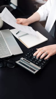 Successful Financial Planning: Businesswoman in Accounting. Close-Up of Accountant at Work. Document and Calculator in Hand. Efficient Budget Assessment. Businesswoman in Finance Role.