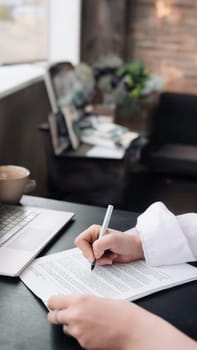 Young Woman's Hand Signing Official Document. Business, Legal, Finance, Notary, Trade, Credit, Accounting Concept. Woman signing an official document, a woman's hand with a pen signs a paper contract