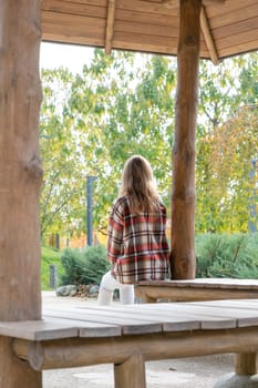 Woman in red plaid shirt enjoying nature sitting in Japanese Garden