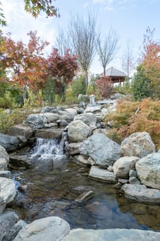 Woman in red plaid shirt enjoying nature sitting in Japanese Garden