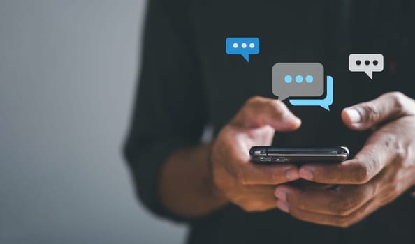Man hand swiftly types on smartphone, live chat in progress, embodying concepts of social network and chatting. Chat box icons pop up, encapsulating technology-driven nature of social medimarketing.