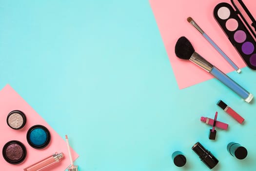 Make up essentials. Set of professional make up brushes, creams and shadows in jars on blue background. Place for your text or logo. Ideal for beauty blog.