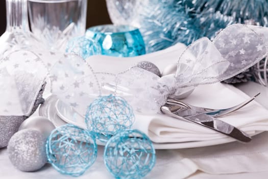 Stylish table with Christmas decoration in turquoise and silver shiny with cutlery