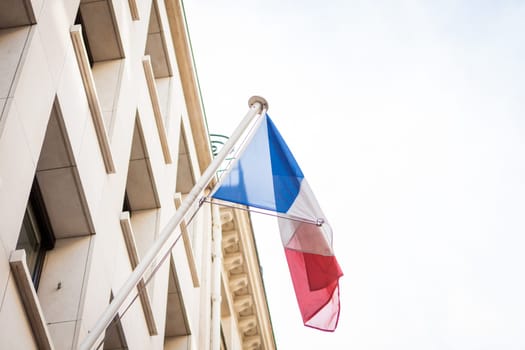 French flag on a flagpole at a building in Paris,France