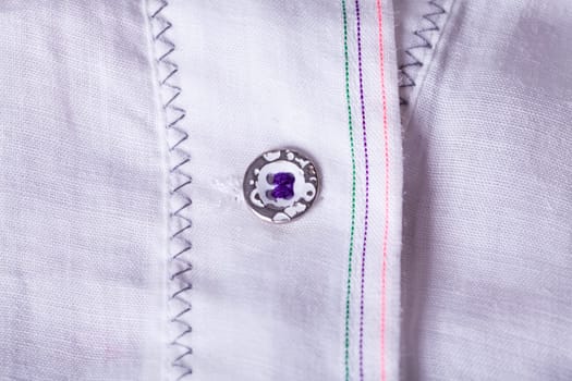 Button strip with button and buttonhole of a blouse as close-up structure texture