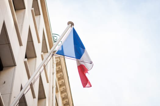 French flag on a flagpole at a building in Paris,France