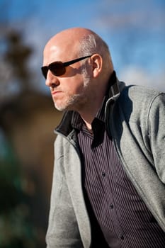 Trendy senior man with sporty clothes relaxes in the outdoors in the sun