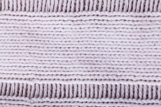 Close-up of a bright fabric tructure knitted from wool background