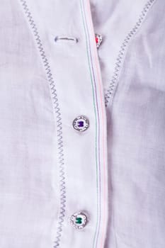 Button strip with button and buttonhole of a blouse as close-up structure texture