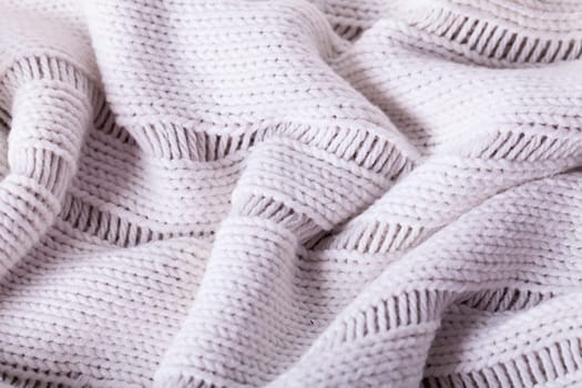 Close-up of a bright fabric tructure knitted from wool background