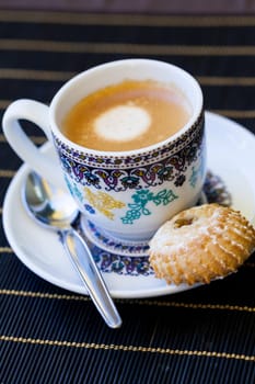 Cup with fresh coffee espresso coffee spoon and pastries as close-up