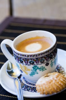Cup with fresh coffee espresso coffee spoon and pastries as close-up