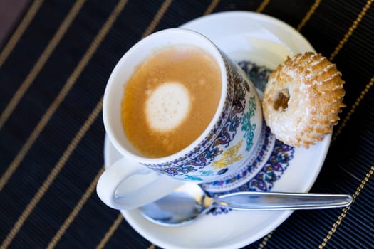 Cup with fresh coffee espresso coffee spoon and pastries as close-up