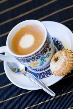 Cup with fresh coffee espresso coffee spoon and pastries as close-up
