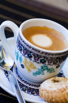 Cup with fresh coffee espresso coffee spoon and pastries as close-up