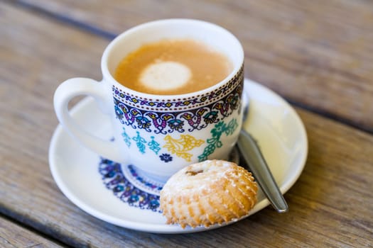Cup with fresh coffee espresso coffee spoon and pastries as close-up