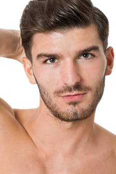 attractive muscular young man with free torso and beard isolated against white background