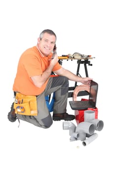 Plumber with materials, laptop and cellphone