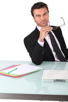 Businessman holding his glasses
