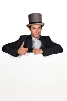 Man dressed in wedding attire with blank message board