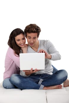 Young couple on sofa with laptop