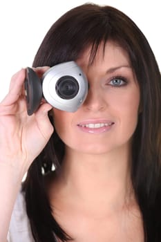 Young woman holding webcam on white background