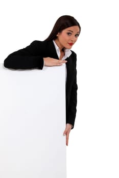 Businesswoman standing behind a white sign