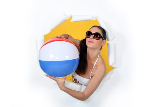Woman with beach ball coming out of hole