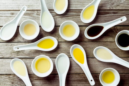 Several soup spoons and sauce dishes arranged randomly on wooden surface