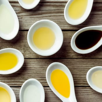 Sauce dish and several soup spoon on wooden surface