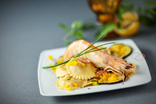 Ravioli and shrimp starter with stuffed round Italian girasole ravioli pasta, roasted aubergine and pink prawn or shrimp
