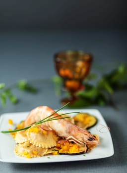 Italian ravioli and shrimp starter with roasted aubergine or eggplant and fresh chives for delcious Mediterranean cuisine