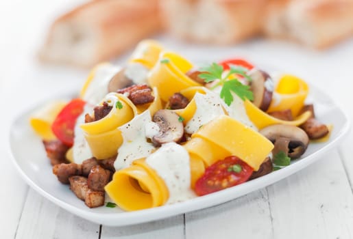 Italian egg noodles with tomato and mushroom drizzled with a savory herb cream sauce for delicious Italian cuisine
