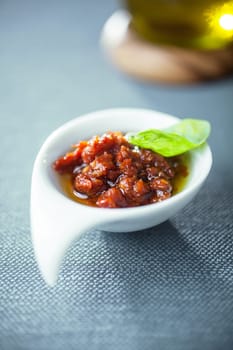 Tasty spicy piquant Italian tomato based sauce or dip served in an elegant bowl topped with a fresh basil leaf