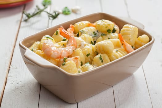 Tasty Italian seafood cuisine with grilled pink prawns in gnocchi pasta, or semolina dumplings, served in a casserole seasoned with fresh herbs