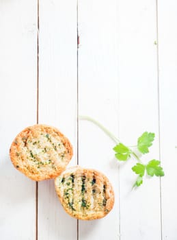 Grilled crusty crisp herb bread on a white wooden table with a sprig of fresh parsley, overhead view with copyspace