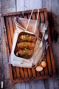 Roulades in Pan with Spoon and Fork, on Wooden Tray and Wooden Background.