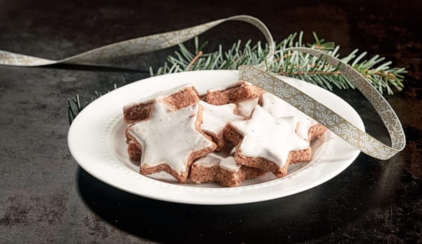 Plate of delicious crunchy Christmas star biscuits glazed with white icing for a festive seasonal snack