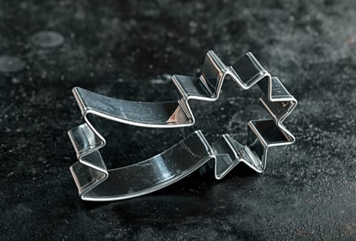 Old silver metal shooting star cookie cutter for making traditional Christmas biscuits symbolic of the Holy Star over Bethlehem at the birth of Jesus