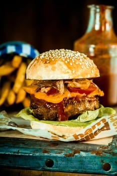 Macro Mouth Watering Handmade Burger Quarter Pounder with Frech Fries in Rustic Style.