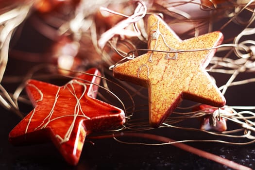 Decorating for Christmas festivities with a jumbled background of two colourful stars with string lying waiting to be hung on the tree