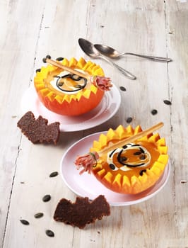 Two Pumpkin Soups with Bat Shaped Crouton Toasts and Broomstick Breadstick Served in Half a Pumpkin with Spoons